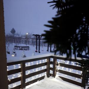 a snow covered park with a fence and benches at Dor de Casa in Doljeşti