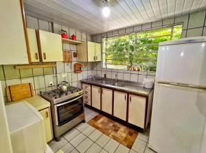 cocina con nevera, fregadero y ventana en Casa Rústica, en Florianópolis