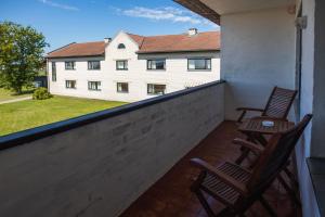 twee stoelen op een balkon met een gebouw op de achtergrond bij Staadioni Hotel in Kuressaare