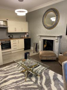 a living room with a table and a fireplace at Merewyke Boutique Family Apartment Sleeps 4 , Only 5 Minutes Walk To Lake Windermere in Windermere