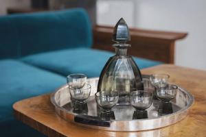 a tray with wine glasses and a decanter on a table at Apartment in the Interwar Villa by Kaunas2022 in Kaunas