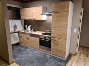 a kitchen with wooden cabinets and a stove top oven at Ferienwohnung Lilith in Brilon