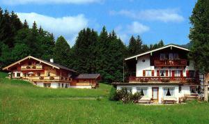 a couple of large wooden houses in a field at Ferienwohnung Lugererlehen in Schönau am Königssee