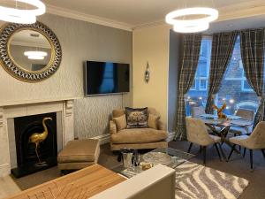 a living room with a fireplace and a dining room at Merewyke Boutique Family Apartment Sleeps 4 , Only 5 Minutes Walk To Lake Windermere in Windermere