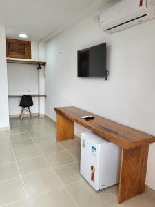 a room with a wooden table and a small refrigerator at Suítes Flecheiras in Flecheiras +19 photos
