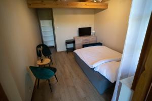niewielka sypialnia z łóżkiem i telewizorem w obiekcie Agroturystyka Sielanka w mieście Przasnysz