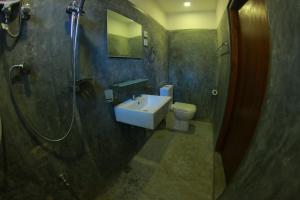 a bathroom with a sink and a shower and a toilet at Monkey Beach in Dickwella