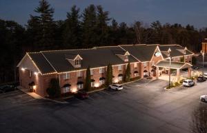 uma vista superior de um edifício com carros estacionados num parque de estacionamento em Mountain Inn & Suites Flat Rock em Flat Rock