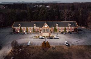 uma vista aérea de um grande edifício com estacionamento em Mountain Inn & Suites Flat Rock em Flat Rock