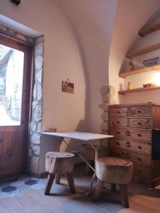 einen Tisch und zwei Hocker in einem Zimmer mit einer Kommode in der Unterkunft Joli petit appartement Montagne#SKI#LAC#NETFLIX# in Seyne