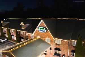 un edificio con luces de Navidad en un lado en Mountain Inn & Suites Flat Rock, en Flat Rock