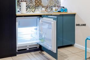 an empty refrigerator with its door open in a kitchen at Apartamenty Centrum z wanną dwuosobową in Piotrków Trybunalski
