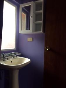 a blue bathroom with a sink and a window at Mini Studio cerca de playa in Viña del Mar