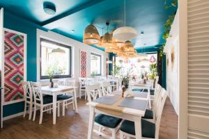 ein Restaurant mit weißen Tischen und Stühlen und blauen Decken in der Unterkunft Fregata in Ustka
