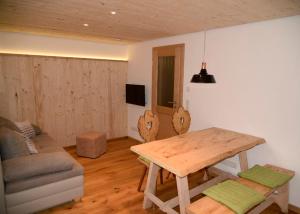 a living room with a wooden table and a couch at Mühle zu Waching in Brannenburg