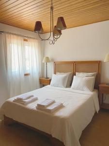 een slaapkamer met een groot wit bed en handdoeken bij Casa de Alventela - Countryside House in Paredes de Viadores