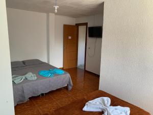 a bedroom with a bed with towels on the floor at Pousada estância gaúcha in Guarapari