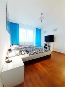 ein großes Bett in einem Zimmer mit blauen Vorhängen in der Unterkunft Apartament Bachusik in Zielona Góra