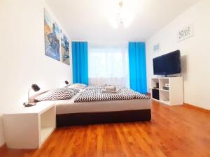 Schlafzimmer mit einem Bett und einem Flachbild-TV in der Unterkunft Apartament Bachusik in Zielona Góra