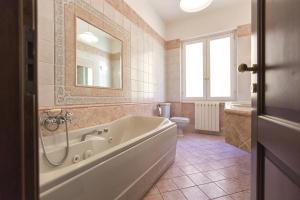 a bathroom with a tub and a toilet and a mirror at Alghero appartamento Medina per 6 ospiti in centro storico in Alghero +41 photos