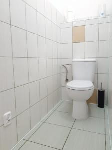 ジェロナ・グラにあるApartament Bachusikの白いタイル張りの客室で、バスルーム(トイレ付)が備わります。