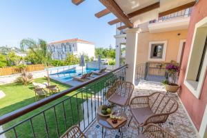 a balcony of a house with chairs and a table at Perla Luxury Living in Parga