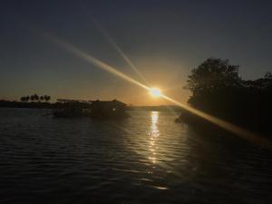 a sun setting over a body of water at Pousada Porto Marola in Porto De Galinhas