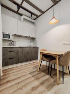 MyApartments Kotka في تالين: مطبخ وغرفة طعام مع طاولة وكراسي
