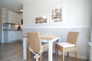 a kitchen with a table and two chairs at STRANDIDYLL, 64 - Typ A1S in Grömitz