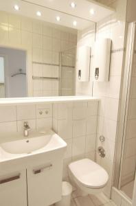 een witte badkamer met een toilet en een wastafel bij STRANDIDYLL, 64 - Typ A1S in Grömitz