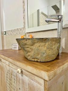 Łazienka z kamienną umywalką na drewnianym blacie w obiekcie Sa Domo de Tzia Elene w mieście Irgoli