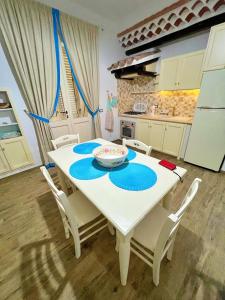 una mesa blanca y sillas en una cocina en Sa Domo de Tzia Elene, en Irgoli
