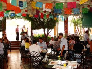 a group of people sitting at tables in a restaurant at Hotel Palmareca in Tuxtla Gutiérrez