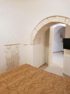 um quarto com uma cama e um arco em TRULLO GIUVICA em Locorotondo