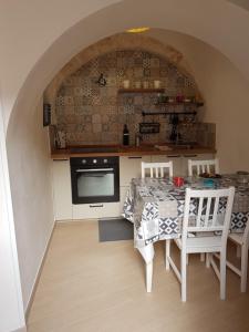 uma cozinha com uma mesa e cadeiras e uma cozinha com um arco em TRULLO GIUVICA em Locorotondo