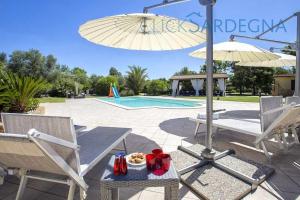 un tavolo con un piatto di cibo e un ombrello di Alghero Villa Paradiso lusso per 12 ospiti ad Alghero