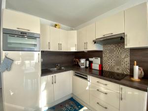  La cuisine est équipée de placards blancs et d'un réfrigérateur. dans l'établissement REF 062 Appartement T3 pour quatre personnes proche port Crouesty à ARZON, à Arzon