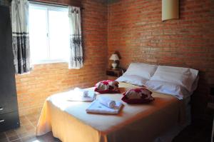 a bedroom with a bed with towels and a brick wall at Aguila Blanca in Mina Clavero