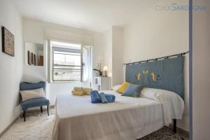 阿尔盖罗Attico Mir el Mar Alghero con spettacolare terrazza panoramica vista mare的卧室里有一张带蓝色床头板的大床