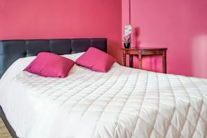 ロストフ・ナ・ドヌにあるOne-two-roomed flats on Gvardeyskiyのピンクのベッドルーム(ピンクの枕が付いた白いベッド付)