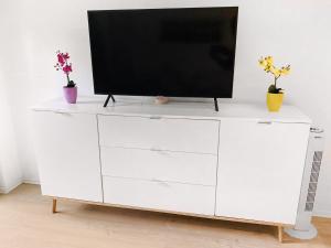 a white dresser with a television on top of it at Little Black Forest Garden in Pforzheim