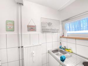 uma cozinha branca com um lavatório e uma janela em Little Black Forest Garden em Pforzheim