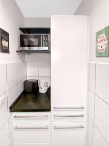 a kitchen with white cabinets and a microwave at Little Black Forest Garden in Pforzheim