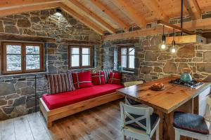 ein Wohnzimmer mit einem roten Sofa und einem Tisch in der Unterkunft Mountain Lodge Istria, Tiny house in Roč
