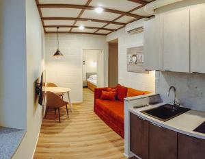 a kitchen and a living room with a couch and a table at MyApartments Kotka in Tallinn