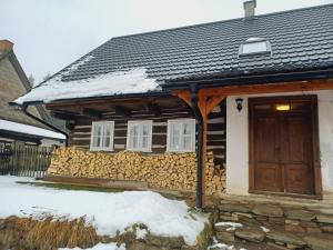a house covered in snow with a wooden door at Chalupa Anežka in Králíky