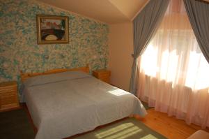 a bedroom with a bed and a window at COMPLEX HARMONY/КОМПЛЕКС ХАРМОНИЯ in Tryavna