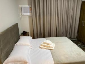 a bed with two towels sitting on top of it at Apartamento praia BC Central novo in Balneário Camboriú