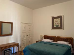 um quarto com uma cama com um cobertor verde em Petrópolis Palácio Quitandinha em Petrópolis