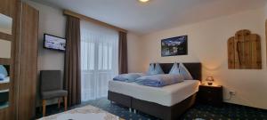 A bed or beds in a room at Pension Schweizerhof